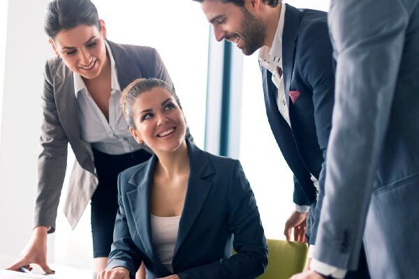 business professionals-smiling and standing-around a table